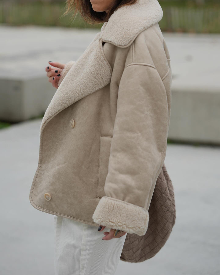 Beige sherpa jacket worn by a person with a blurred background