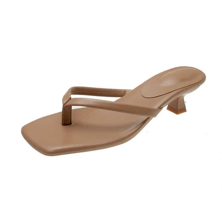Tan sandal with a small heel on a white background
