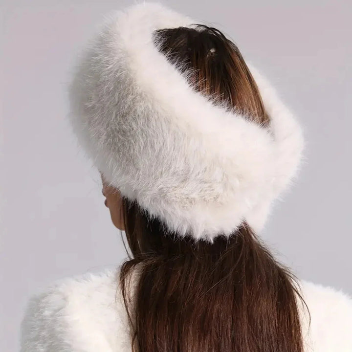 White fur headband worn by a person with a plain background