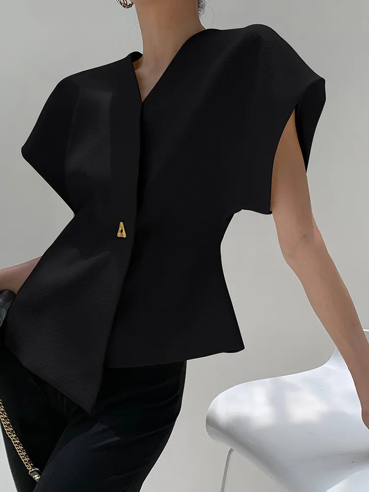 Black sleeveless blazer with a gold button on a neutral background