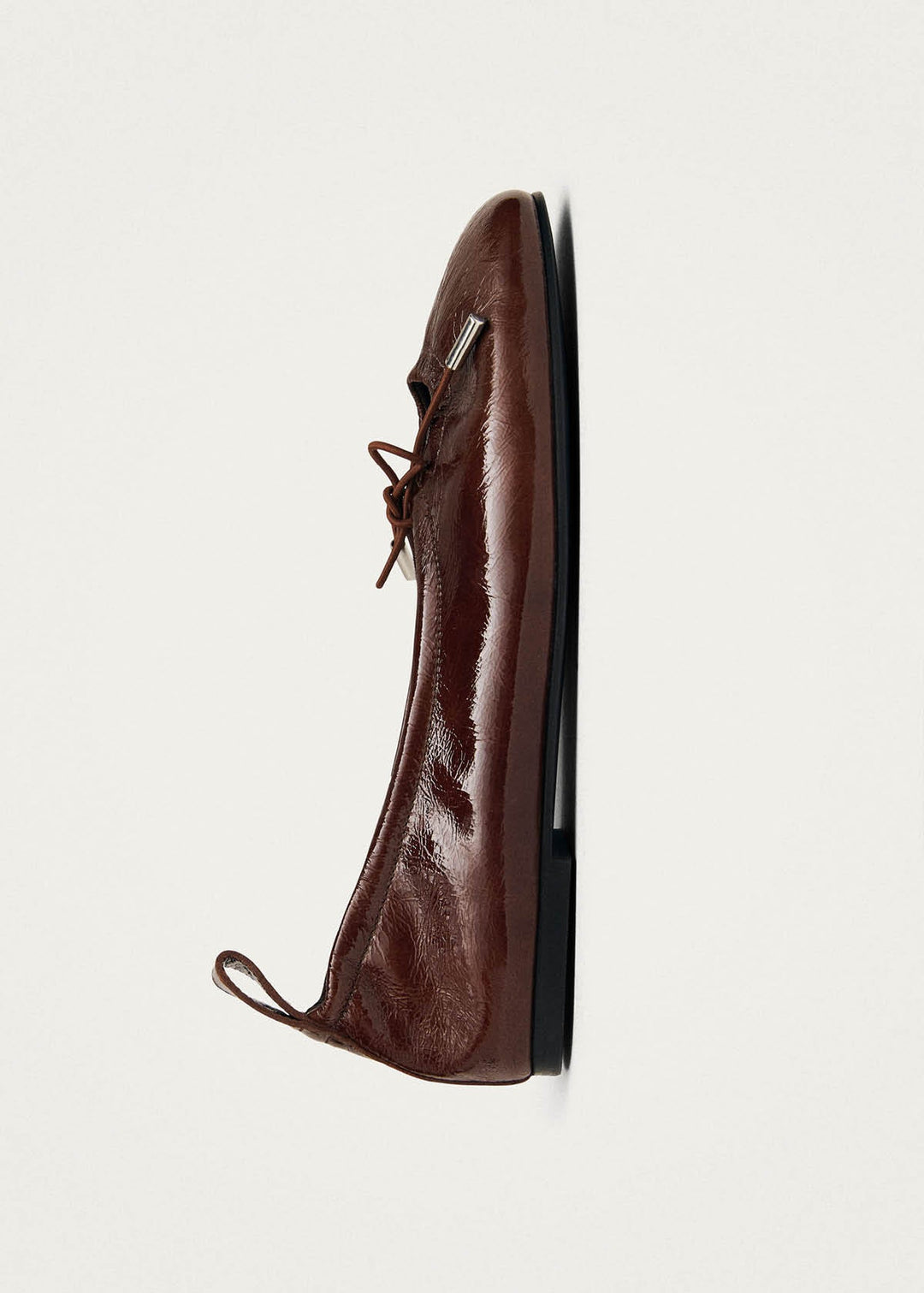 Brown leather shoe on a light gray background