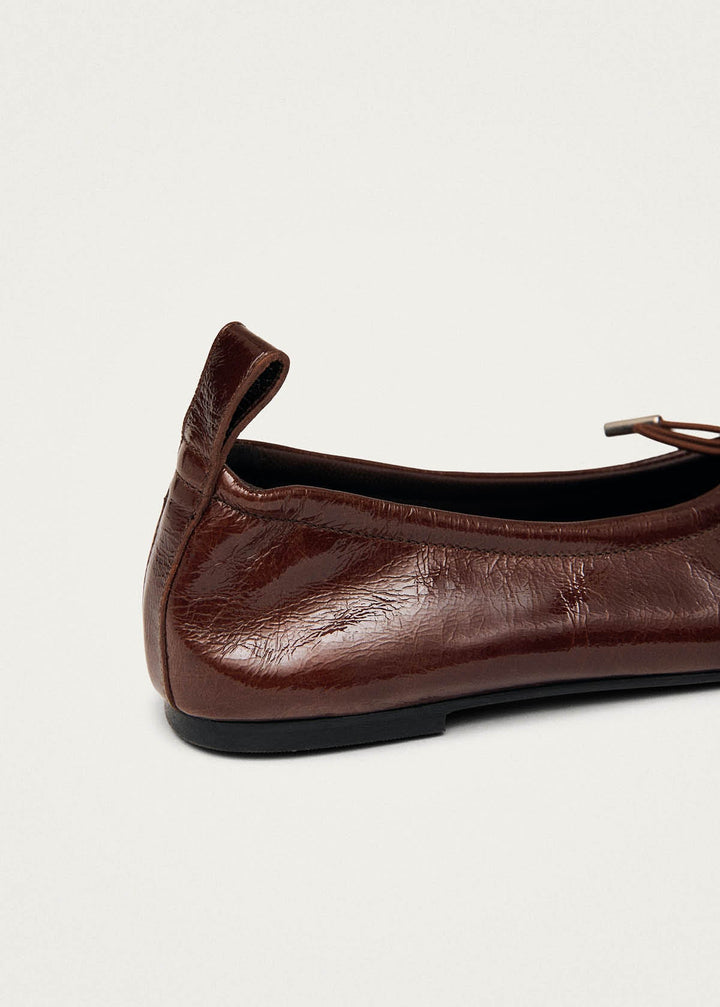 Brown leather flat shoe on a light gray background